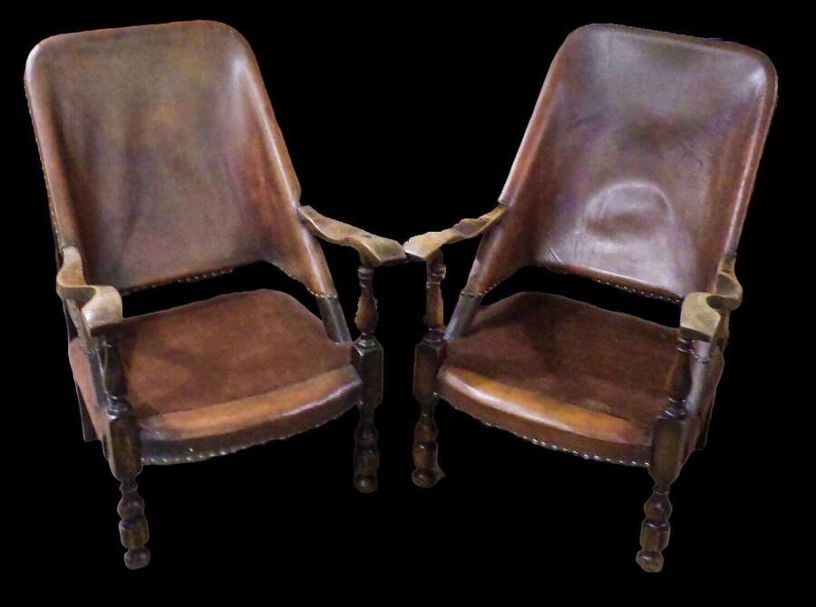 A pair of Oak and Leather Safari Colonial Chairs